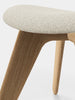 Natural slab ottoman by Tom Dixon with boucle upholstery, showcasing a modern, minimalist seating design in neutral tones.