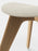 Natural slab ottoman by Tom Dixon with boucle upholstery, showcasing a modern, minimalist seating design in neutral tones.