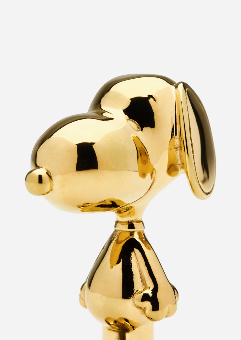 Snoopy-designed accessories by Skultuna featuring a Snoopy figure with a sleek, modern design in metal finish.