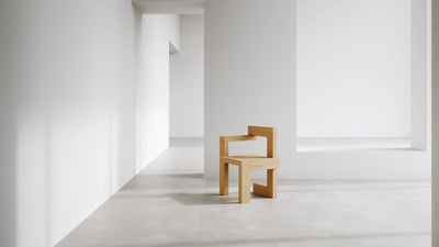 Pastoe Stelman Chair with left armrest, modern seating with sleek design and wooden legs, showcasing contemporary home furniture.