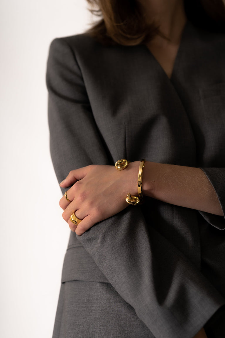 Gold plated Massive Knot cuff bracelet by Skultuna, showcasing a bold, intertwined knot design in a close-up view.