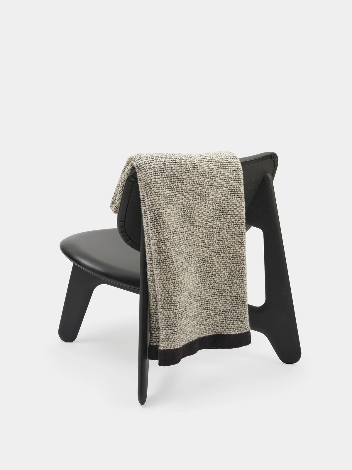 Black Thread Throw by Tom Dixon, a cozy accessories piece with textured woven fabric, displayed on a neutral background.