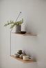 Woud Stedge floating storage shelf with minimalist design and natural wood finish, mounted on a wall for modern home organization.
