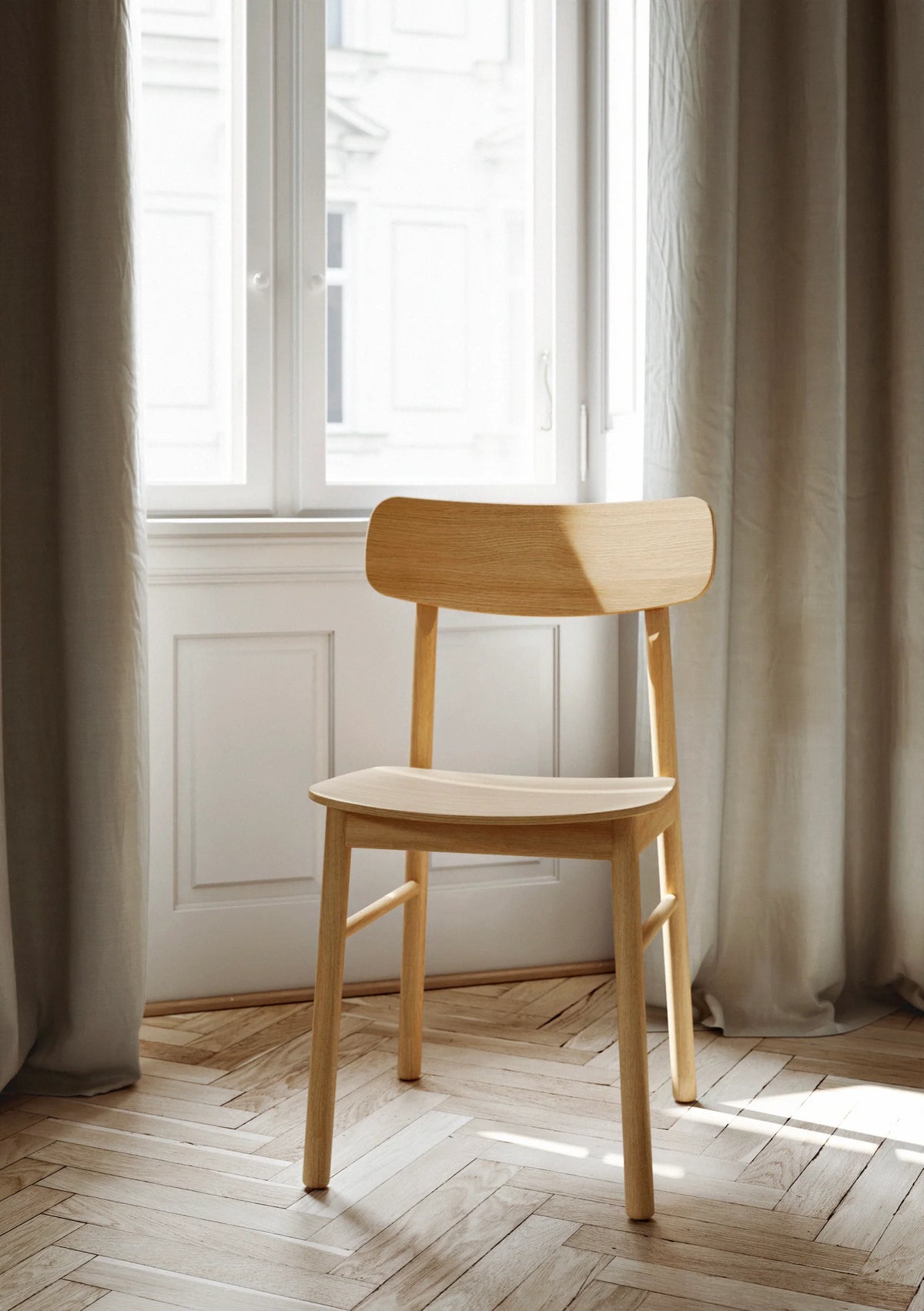 Soma dining chair by Woud Denmark with a modern design, featuring a wooden frame and a comfortable upholstered seat.