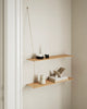 Woud Stedge floating shelf mounted on a wall with decorative objects, showcasing minimalist Danish storage design.
