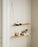 Woud Stedge floating shelf mounted on a wall with decorative objects, showcasing minimalist Danish storage design.