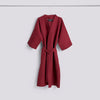 Burgundy waffle bathrobe by Hay, cozy and textured accessories made from soft fabric, displayed hanging against a neutral background.