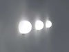 Flos Glo-Ball Wall lighting fixture mounted on wall, featuring a sleek, rounded glass shade and modern design.
