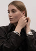 Silver plated Écume De Mer bangle by Skultuna, featuring a textured wave design, worn as stylish jewelry accessory.