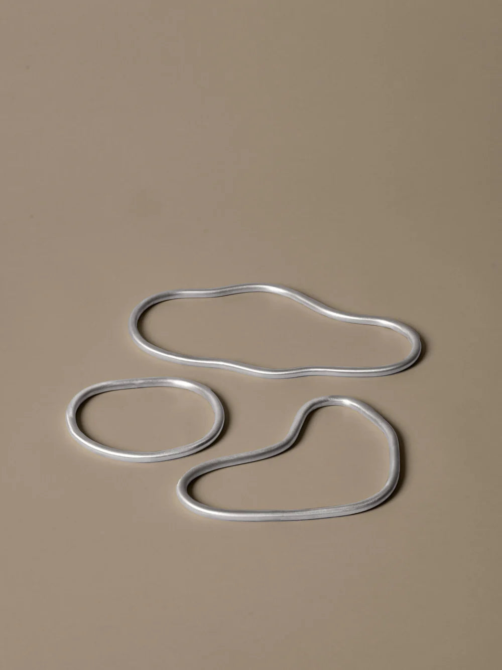 Set of three Ferm Living Pond trivets made of aluminum, decorative accessories for protecting surfaces from hot dishes.