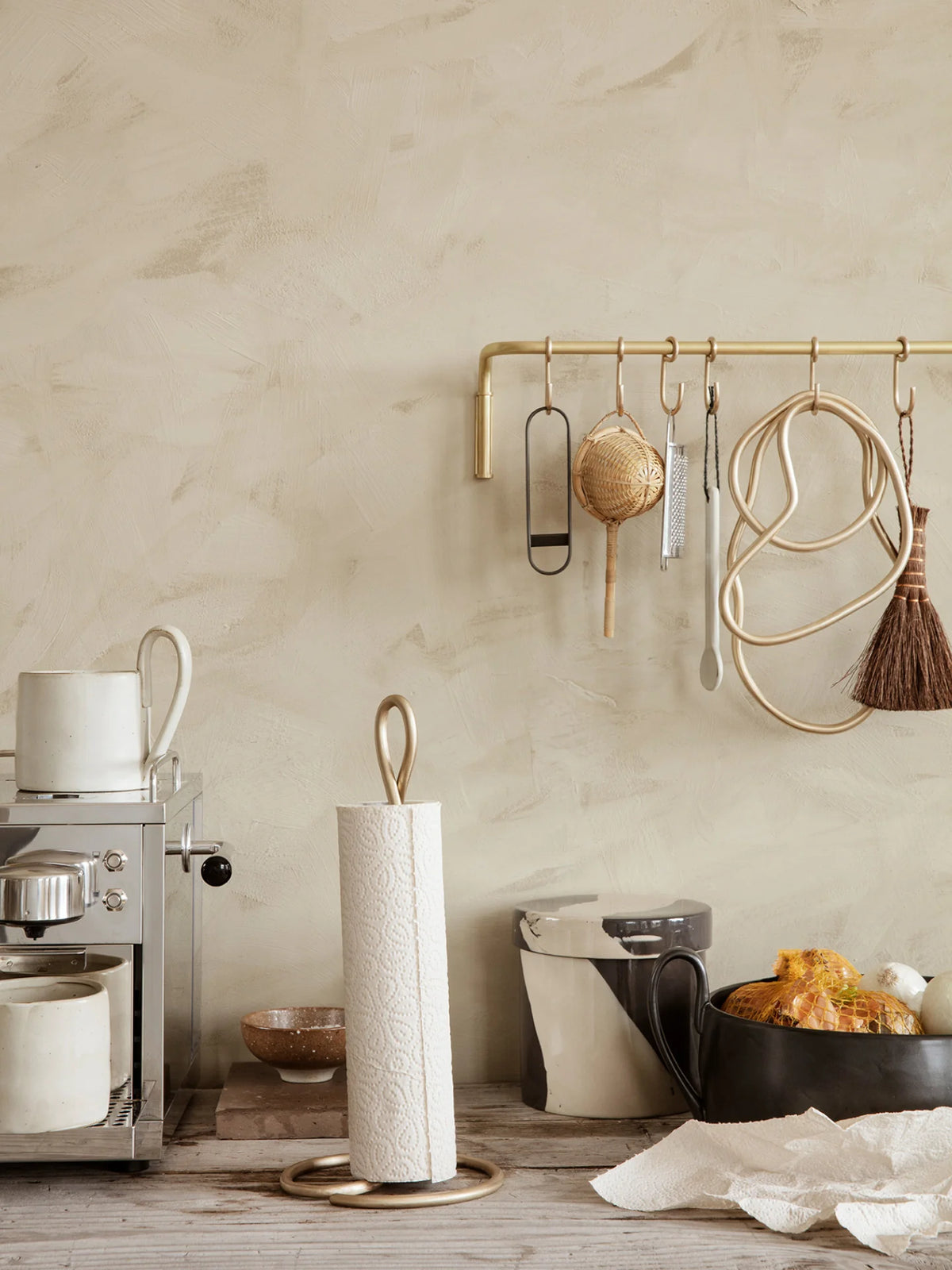 Brass Curvature Paper Towel Holder by Ferm Living, modern kitchen accessory with sleek curved design and sturdy base.
