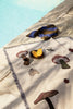 Ferm Living Forest Tapestry Blanket draped over a chair, showcasing its nature-inspired forest design and soft, cozy fabric.