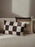 Fold patchwork cushion by Ferm Living featuring undyed fabric in green and natural tones, showcasing a cozy, textured accessory for home decor.
