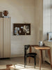Black Ferm Living Herman Dining Chair with wooden legs, showcasing modern seating design and sleek craftsmanship.