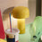 Yellow Bellhop Portable Table Lamp by Flos, compact lighting with a modern design, shown on a neutral background.