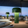 Bellhop Portable Table Lamp by Flos in green, showing its compact, modern design with a handle and illuminated light source.