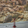Red Toio Floor Lamp by Flos showcasing a sleek, modern lighting design with a curved, adjustable arm and minimalist base.