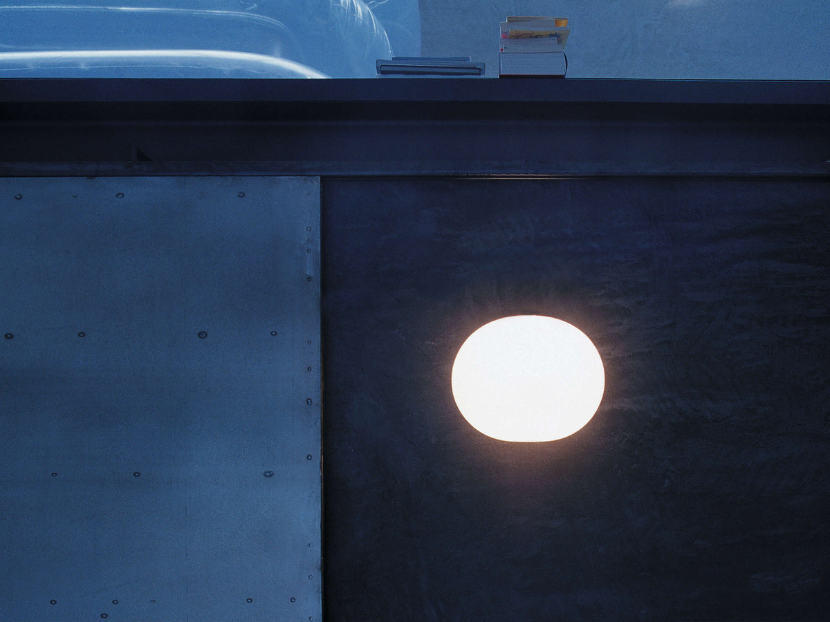 White Glo-Ball Wall lighting fixture by Flos mounted on a wall, showcasing its sleek, rounded design and modern aesthetic.