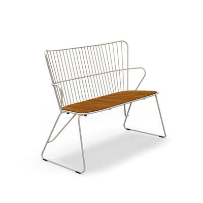White PAON bench by Houe, modern seating with sleek wooden legs and a smooth, curved seat for contemporary outdoor or indoor use.