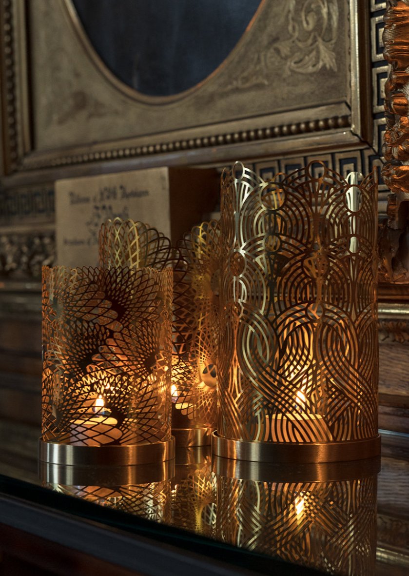 Skultuna Celestial Candle Holder with intricate star design, made of metal, displayed on a wooden surface.