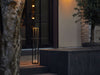 Modern Flos In Vitro Bollard 3 outdoor lighting fixture with sleek design and durable metal finish, illuminated at night.