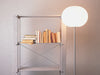 Modern Glo-Ball Floor lamp by Flos in a stylish living room, featuring a spherical glass shade and sleek metal stand.