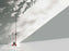 Red Toio floor lamp by Flos standing in a modern living room, showcasing sleek lighting design and adjustable arm.