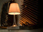 Miss K fabric table lamp by Flos, designed by Starck, featuring a sleek, modern white fabric shade on a minimalist base.