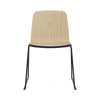 Black steel Just Chair seating by Normann Copenhagen with a sleek modern design, featuring a curved backrest and sturdy frame.