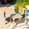Round pedestal cafe table by Bend Goods with a tan outdoor finish, featuring a sleek design suited for outdoor dining spaces.