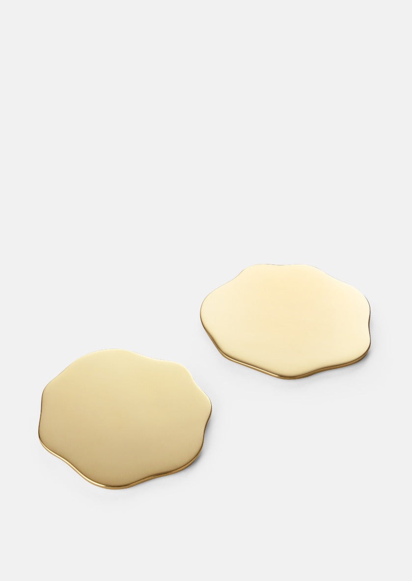 Set of two Skultuna Veermakers Bluebell brass coasters with polished finish, showcasing elegant accessory design.