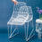 Stacking Lucy seating by Bend Goods, a modern woven chair with a sleek design, shown in white with a black background.