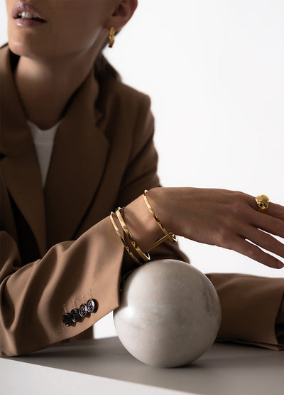 Skultuna Apart Cuff accessory with sleek, minimalist design in polished metal, worn on the wrist with a contemporary style.