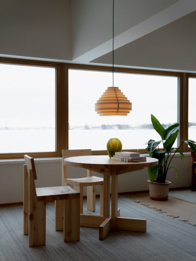 Round Vaarnii dining table with sleek wooden finish, showcasing its smooth surface and modern design perfect for contemporary dining spaces.