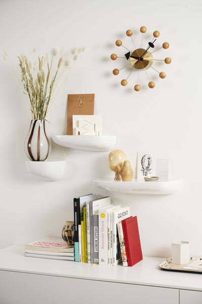 Orange Vitra Ball Clock, a stylish accessory with a spherical design, featuring a modern clock face and minimalist aesthetic.