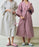 Waffle bathrobe by Hay, soft textured accessories in neutral tones, displayed hanging on a hook.