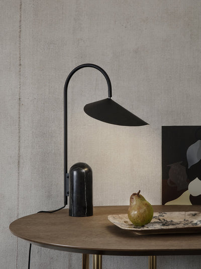 Ferm Living Arum Table Lamp with a sleek, modern design featuring a textured ceramic base and a soft fabric shade.