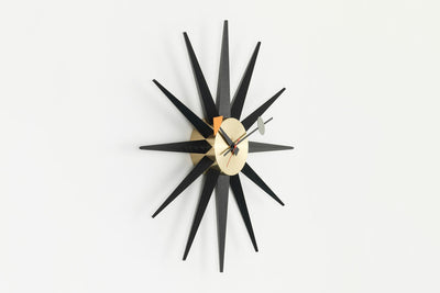 Vitra Sunburst Clock decorative accessory with a vibrant, starburst design mounted on a wall.