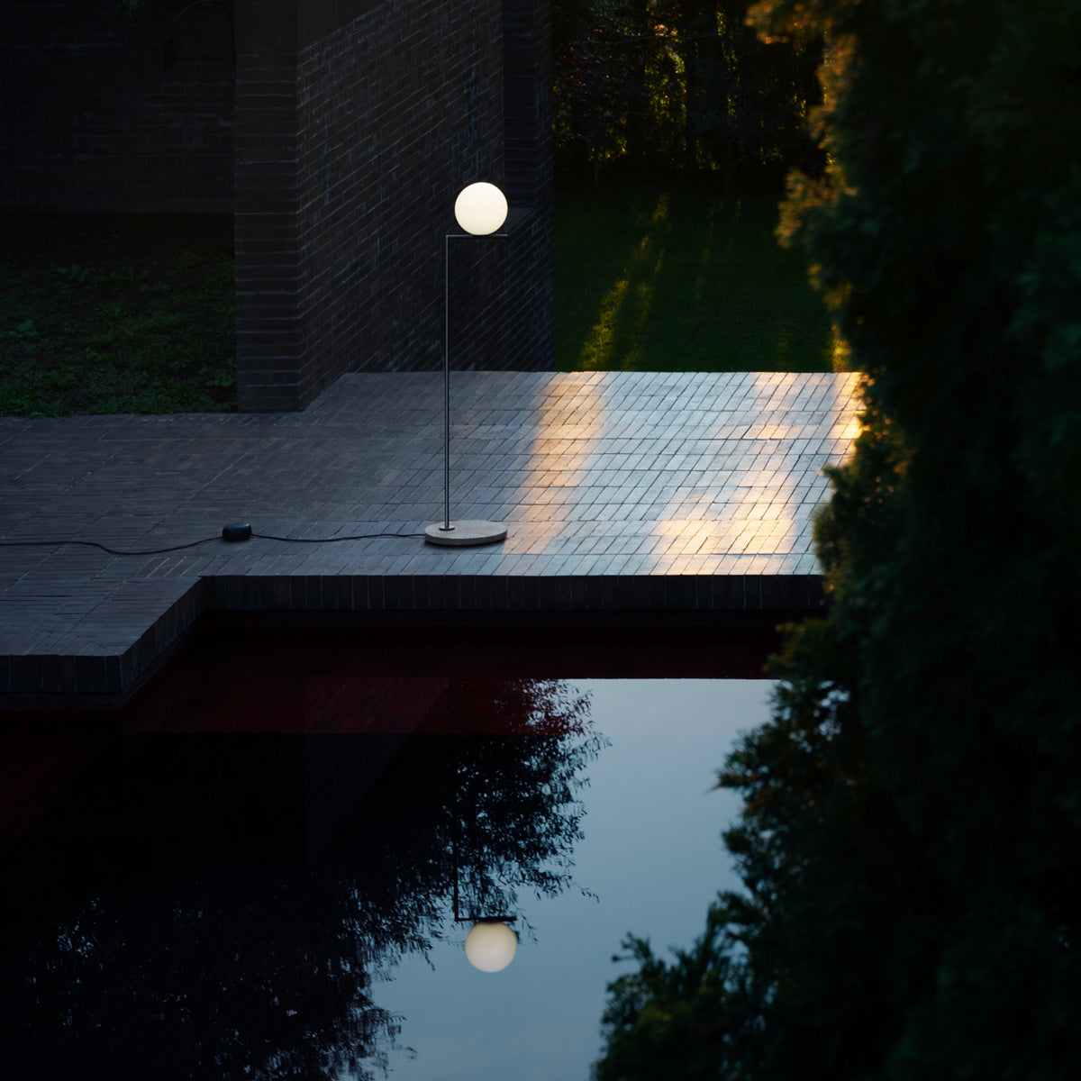 Outdoor Flos IC Lights Floor outdoor lighting fixture with sleek design and integrated LED illumination on a modern patio setting.