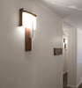 Dark stained walnut Oris wall sconce by Cerno with 2700K LED, American-made lighting fixture mounted on wall.
