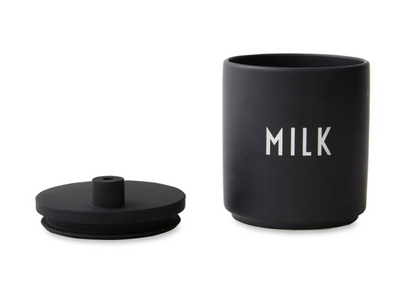 Black porcelain milk jug with silicone lid, designed by Design Letters, featuring a sleek, modern accessory for kitchen or table use.