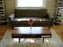 Walnut classic coffee table with nine legs by Eastvold Furniture, showcasing a sleek, modern design in a living room setting.