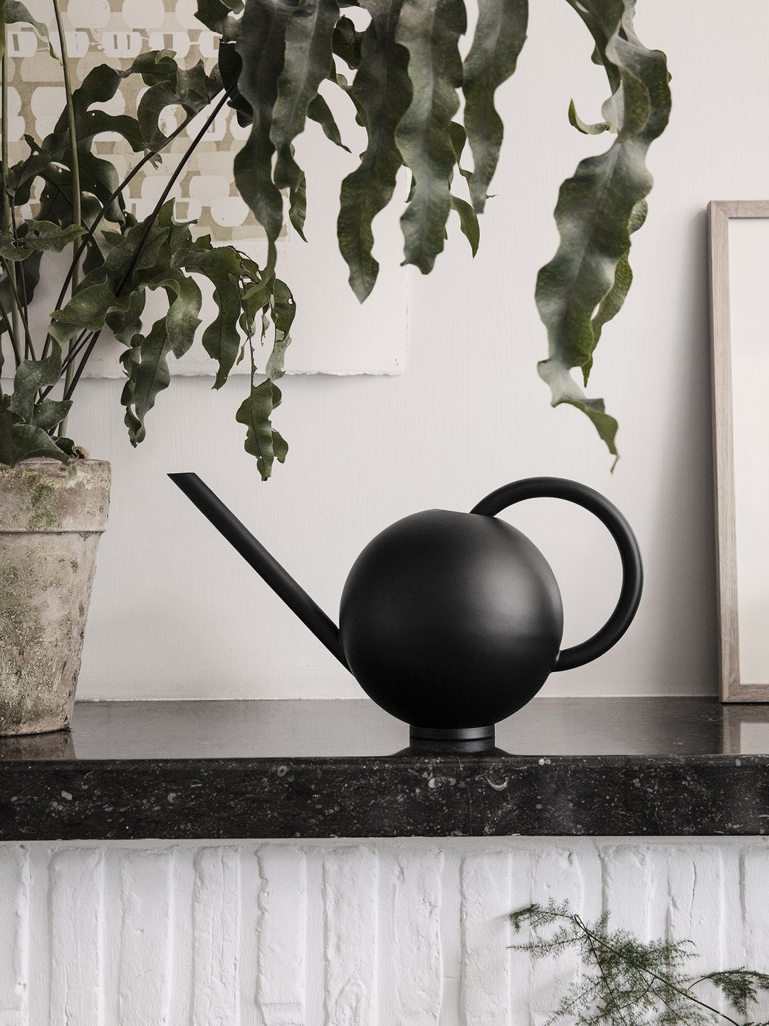 Black Orb Watering Can by Ferm Living, a modern accessory with a sleek, spherical design for watering plants.
