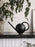 Black Orb Watering Can by Ferm Living, a modern accessory with a sleek, spherical design for watering plants.