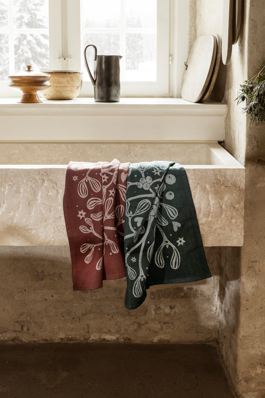 Dark green Mistletoe Tea Towel by Ferm Living, stylish kitchen accessory with festive botanical design.