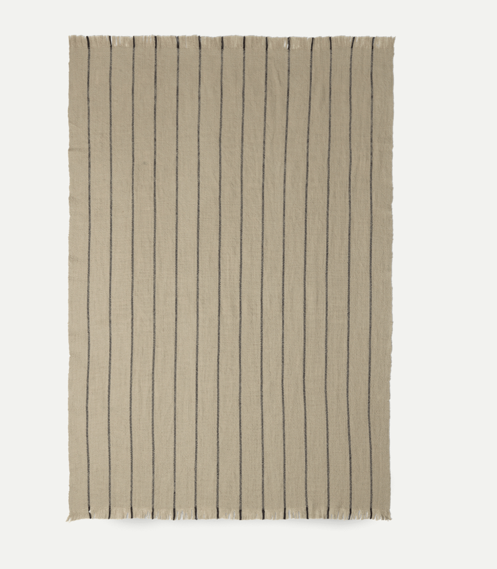 Ferm Living Calm Blanket in soft, neutral fabric, showcasing cozy textured accessories perfect for relaxing home decor.