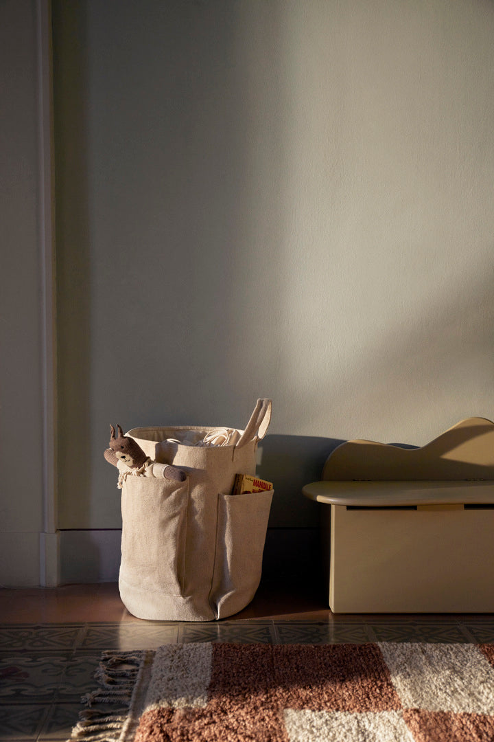 Ferm Living pocket storage bag in neutral fabric with a simple, functional design for organizing small items.