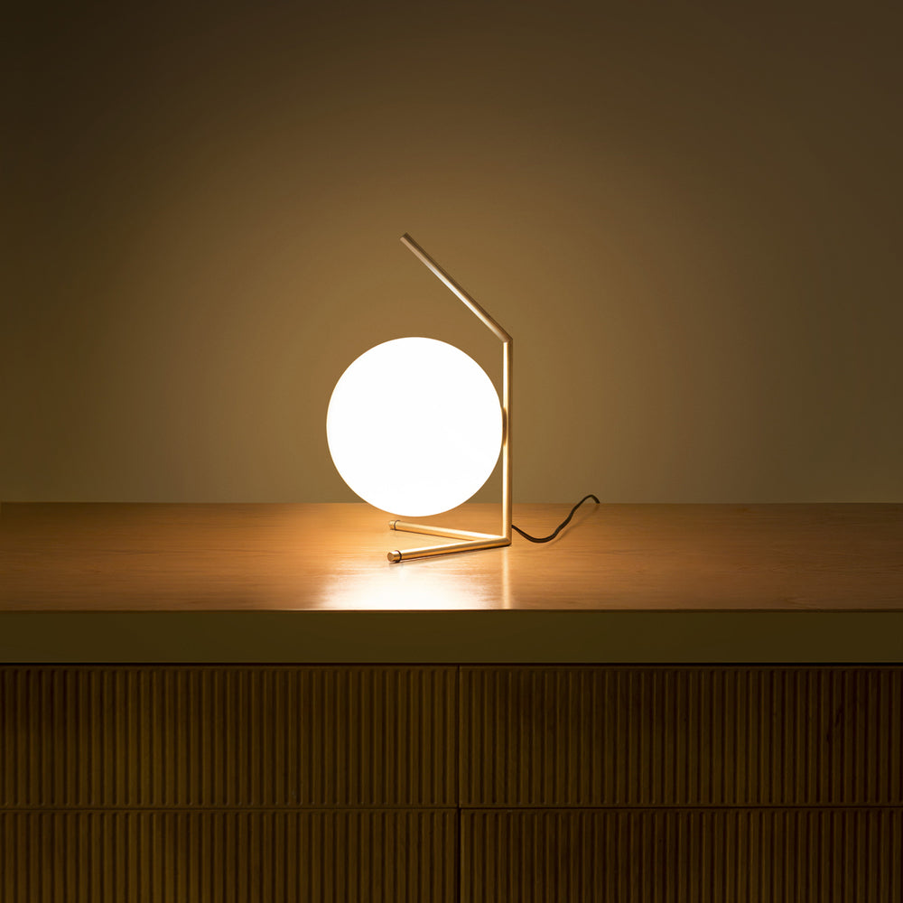 Brass IC Lights Table by Flos, modern lighting fixture with sleek design, featuring a rounded, illuminated glass shade.