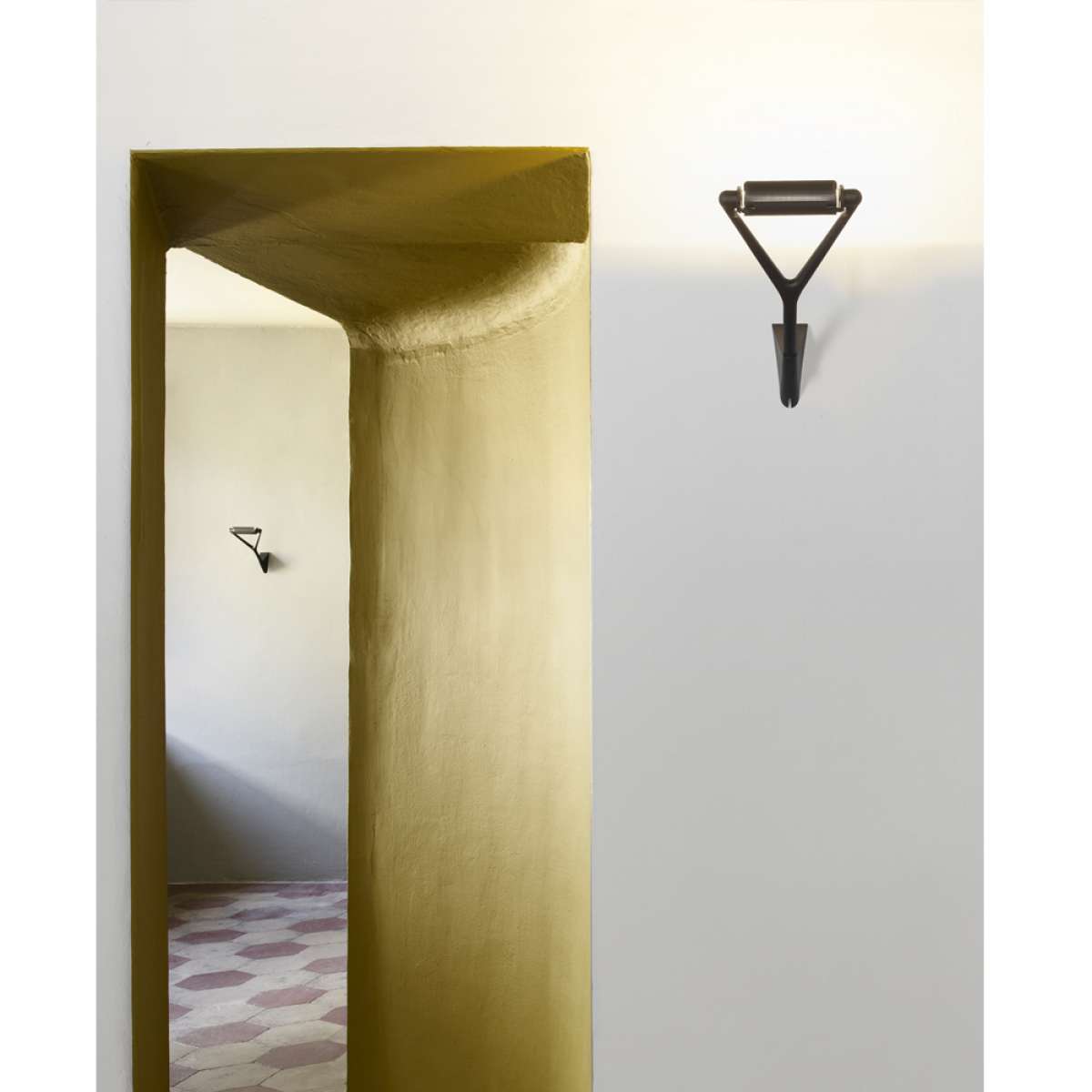 Luceplan Lola wall lamp in modern design, mounted on a white wall, showcasing its sleek, minimalist lighting fixture.