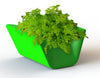 Red Otto Ottoman by Offi serving as a stylish seating bench and planter in a modern interior setting.